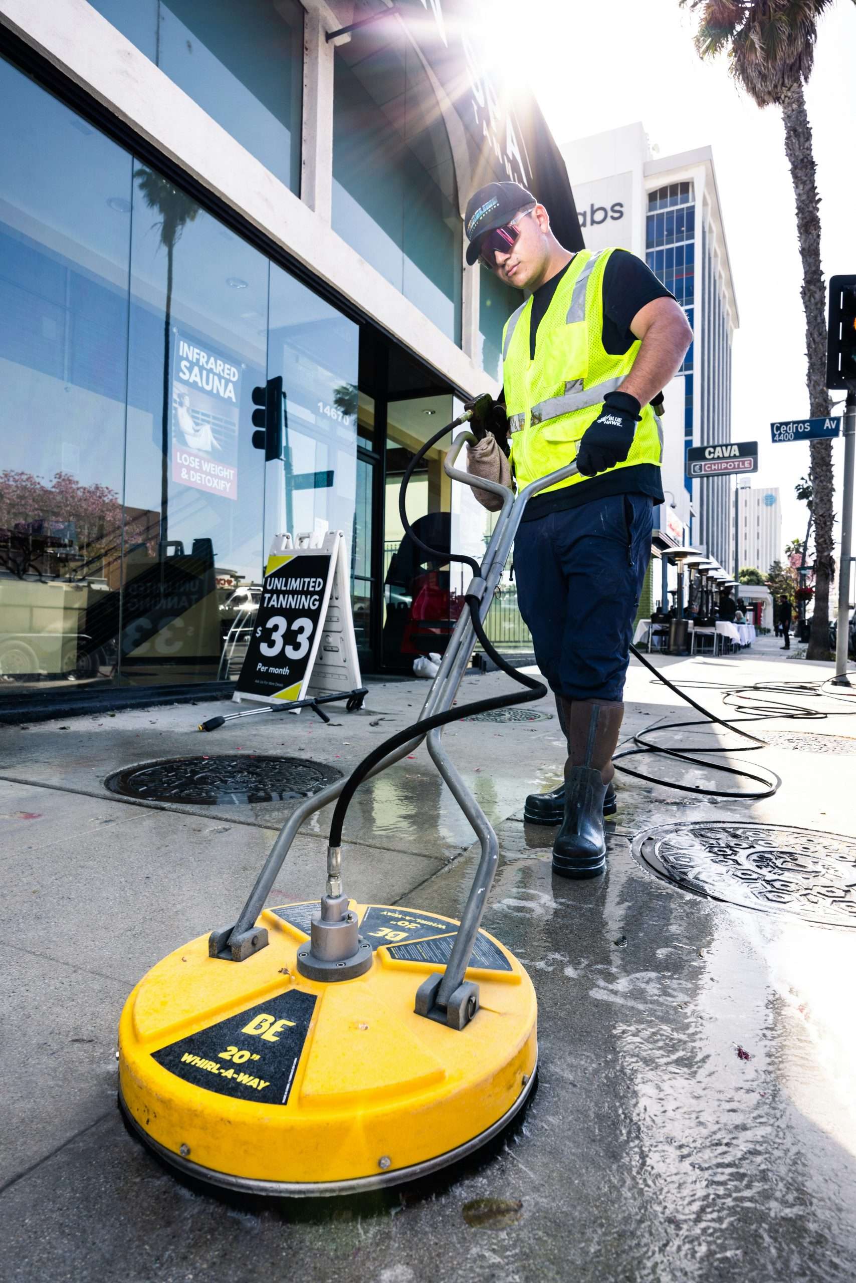 Technician power washing a commercial surface